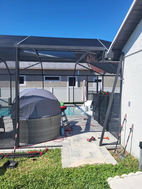 Outdoor covered patio area with trampoline, toys, and landscaping