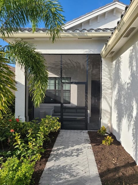 Modern white house exterior with black framed screened entry door