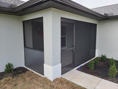Modern white house corner with dark screened doors and windows